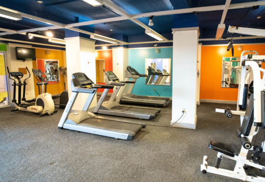 Fitness center with elliptical, treadmill and weights stations.